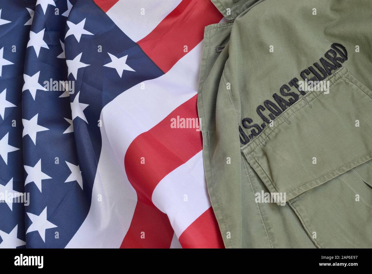 Old US Coast Guard uniform lies on folded United States Flag. Background for Coast Guard day design Stock Photo