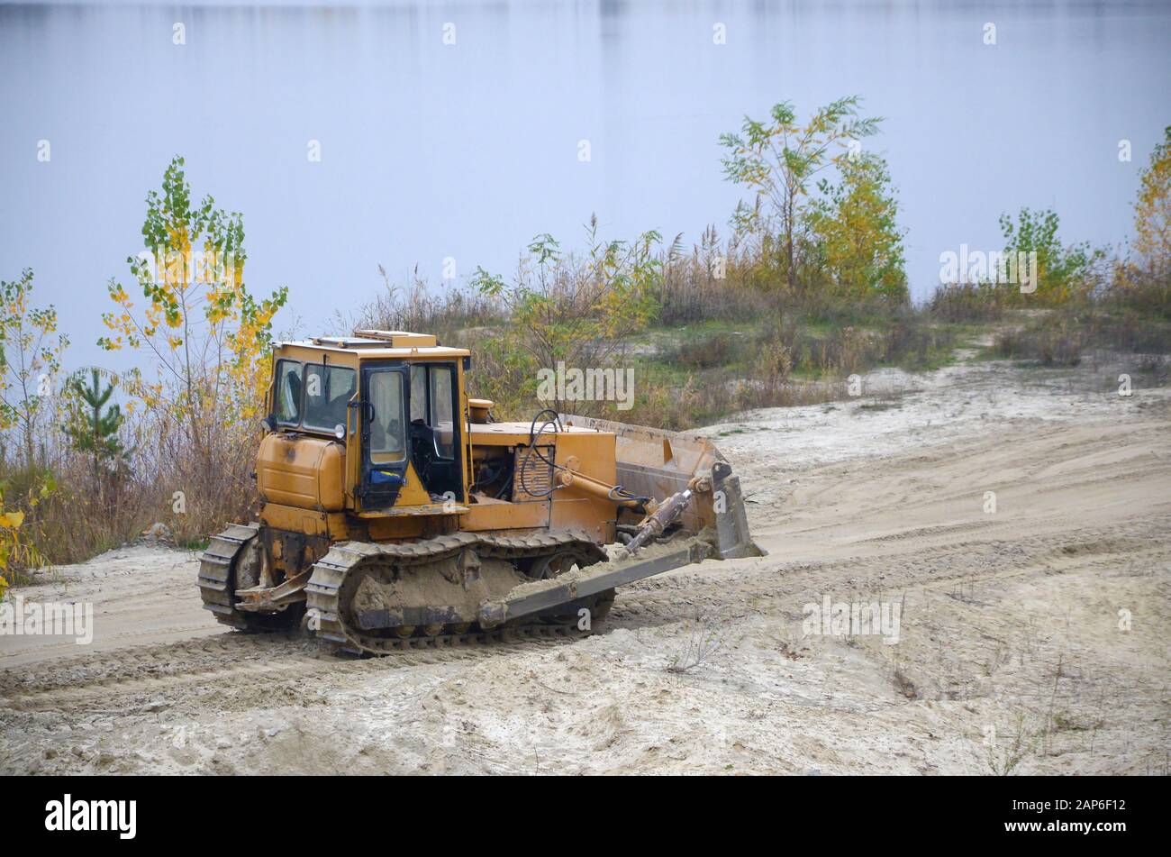 Quarry aggregate with heavy duty machinery on Construction industry. Caterpillar loader Excavator with backhoe driving to construction site quarry Stock Photo