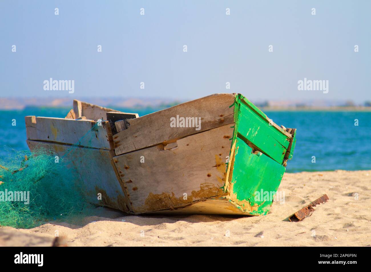 Old wooden fishing boat with fishing net on the beach Stock Photo - Alamy