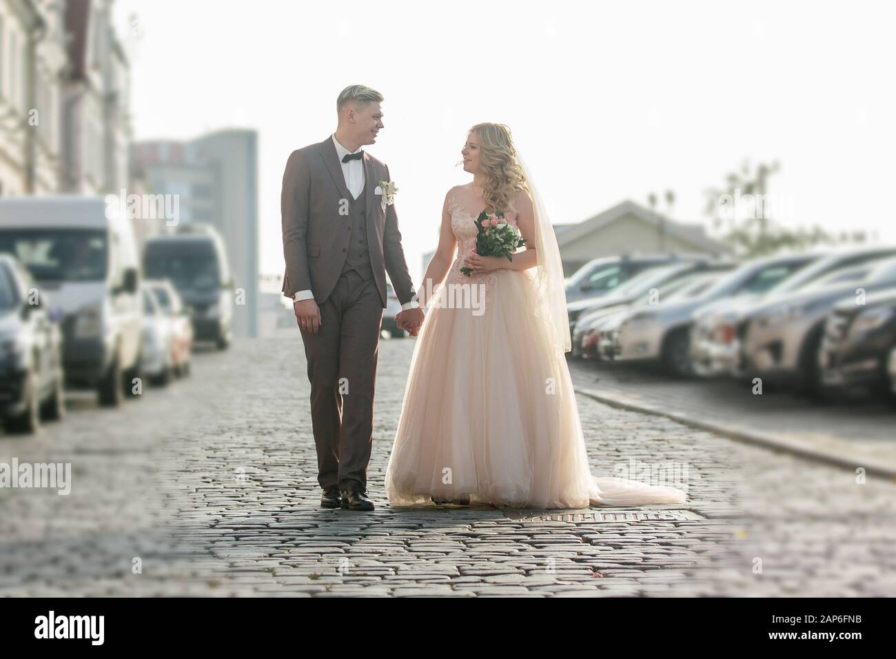happy bride and groom walking on city street Stock Photo - Alamy