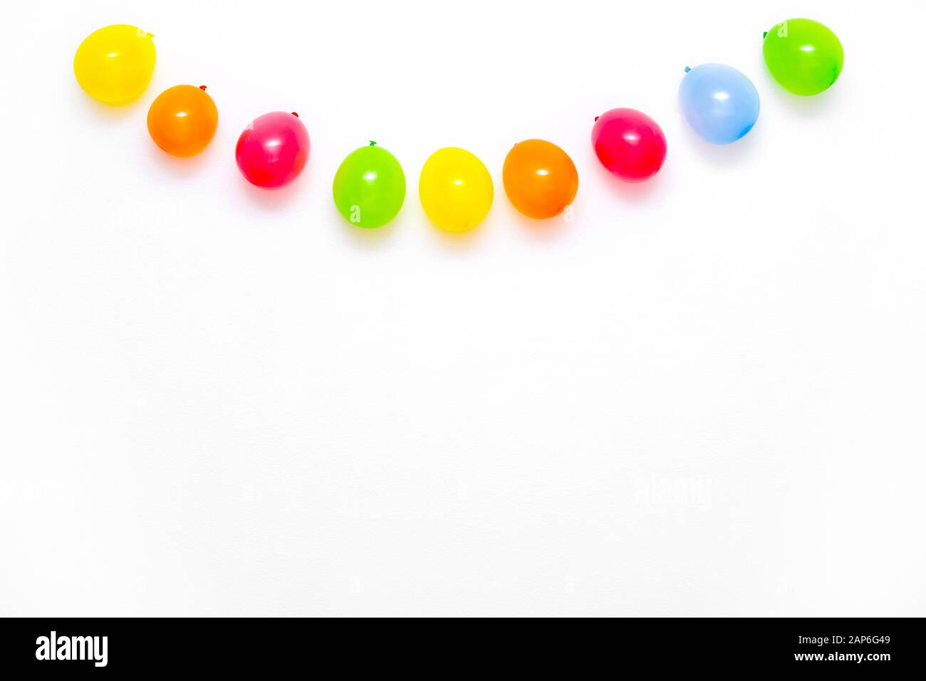 Colorful balloons on white wall or table top view. Festive or party background. Flat lay style. Copyspace for text. Birthday greeting card. Stock Photo