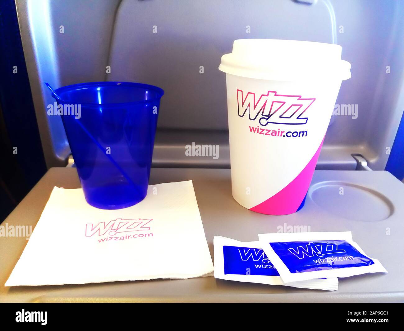 KYIV, UKRAINE - AUGUST 30, 2019: Wizz Air set consisting of two plastic cups, napkin and sugar marked with logos Stock Photo