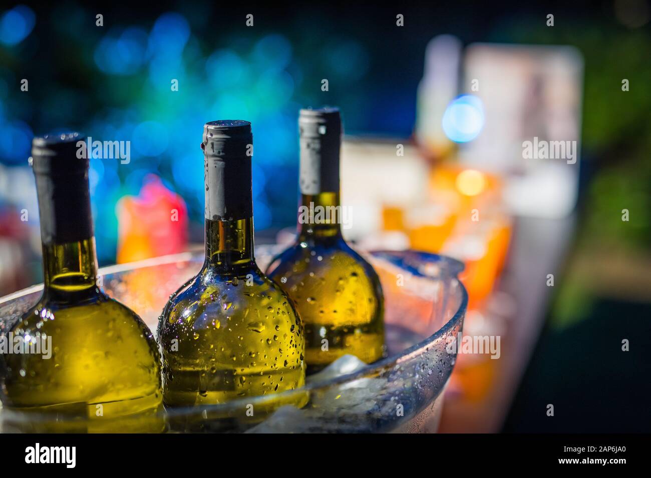 Row of green wine bottles on ice Stock Photo