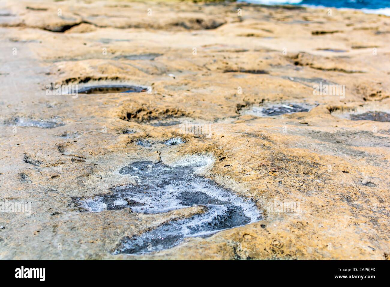 Dried salt on flat rocky Sliema beach, Malta Stock Photo