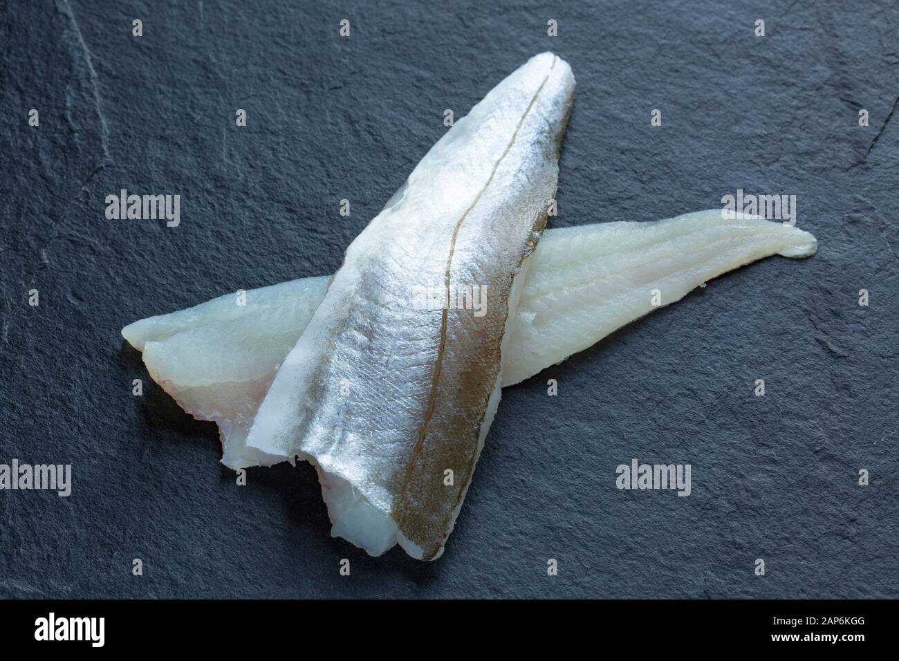 Two raw whiting fillet, Merlangius merlangus, from a whiting caught in the English Channel on rod and line from a boat. The fillets show the flesh and Stock Photo