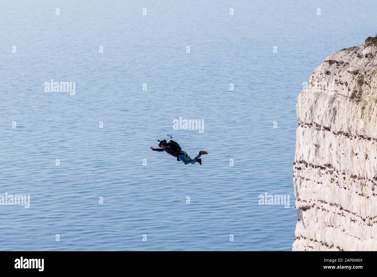 Base jumper leaps off the white cliffs at Beachy Head in Sussex. Stock Photo