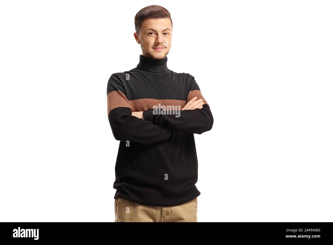 Young smiling guy wearing a turtleneck sweather posing with arms crossed isolated on white background Stock Photo