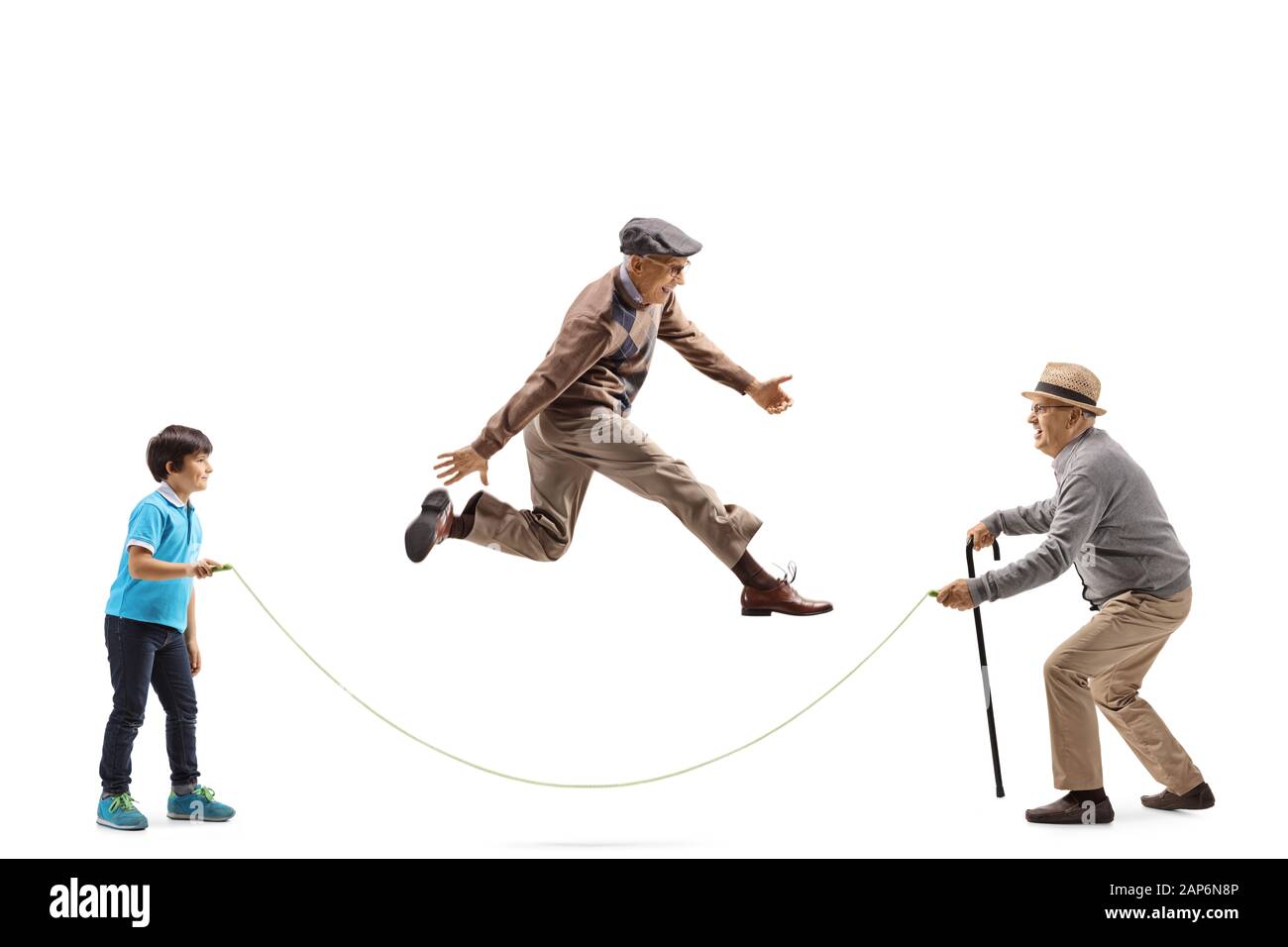 Full length profile shot of a grandfather and grandson holding a rope and an elderly man skipping isolated on white background Stock Photo