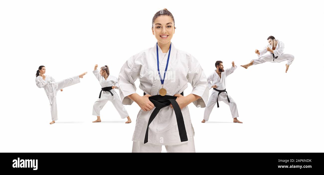 Young female karate champion with a medal posing with people practicing behind isolated on white background Stock Photo