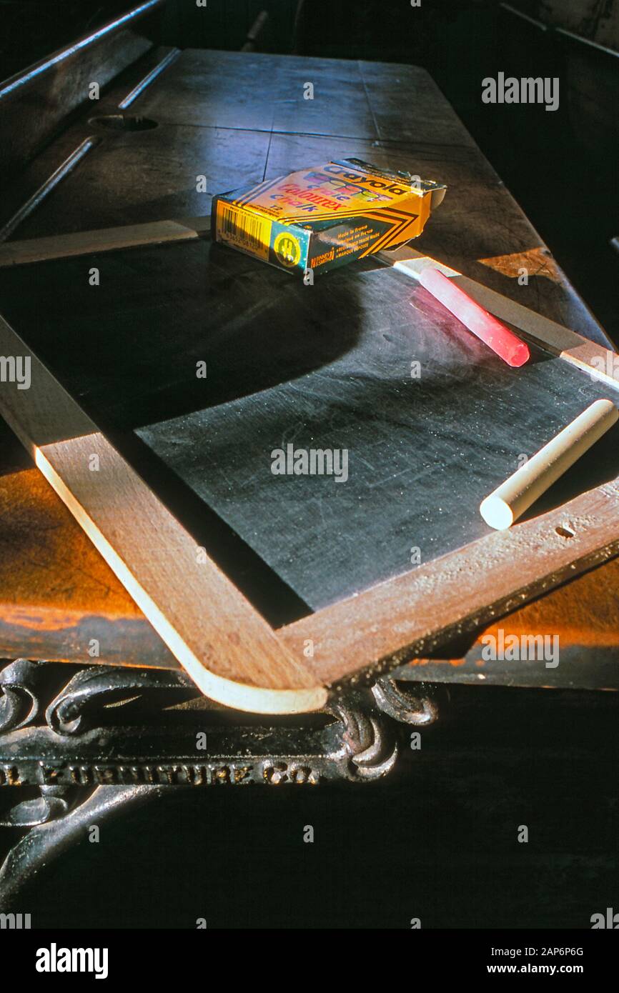 Vintage chalkboard with chalk sticks  on top of an school desk Stock Photo