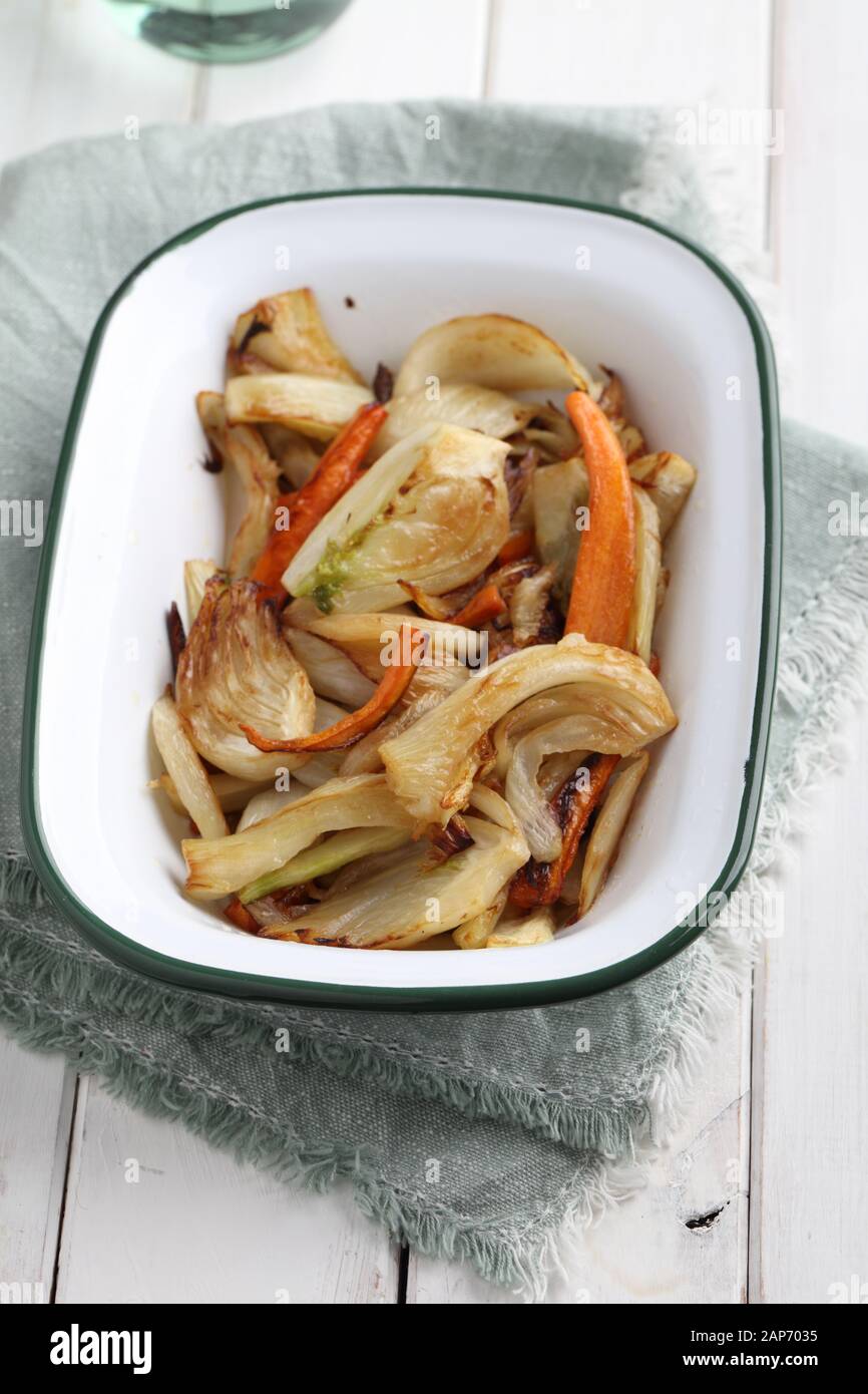 Vegetarian dish, roasted fennel and carrots on a rustic table Stock Photo