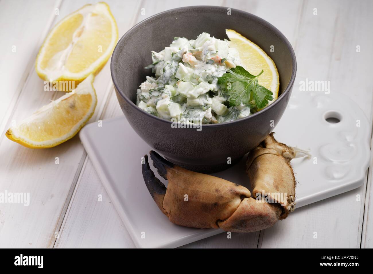 Crab salad and crab claw on a rustic table Stock Photo