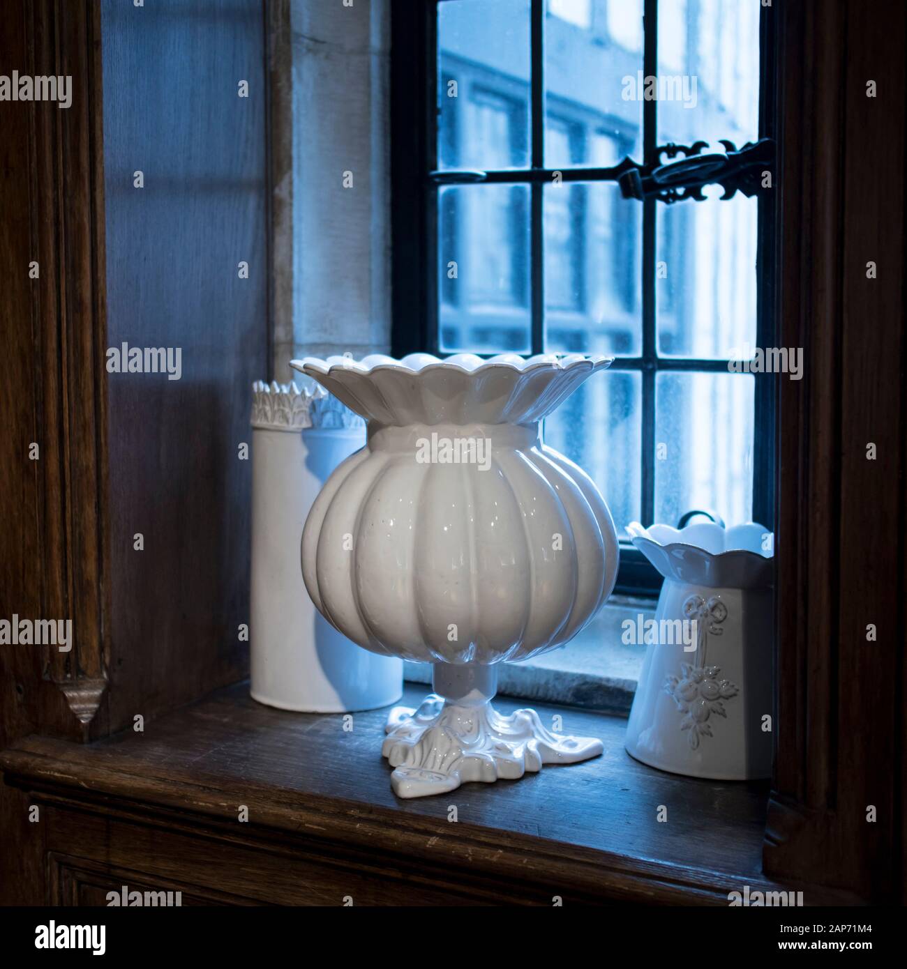 A large white porcelain vase stands on a wooden window sill of an old  English house Stock Photo - Alamy