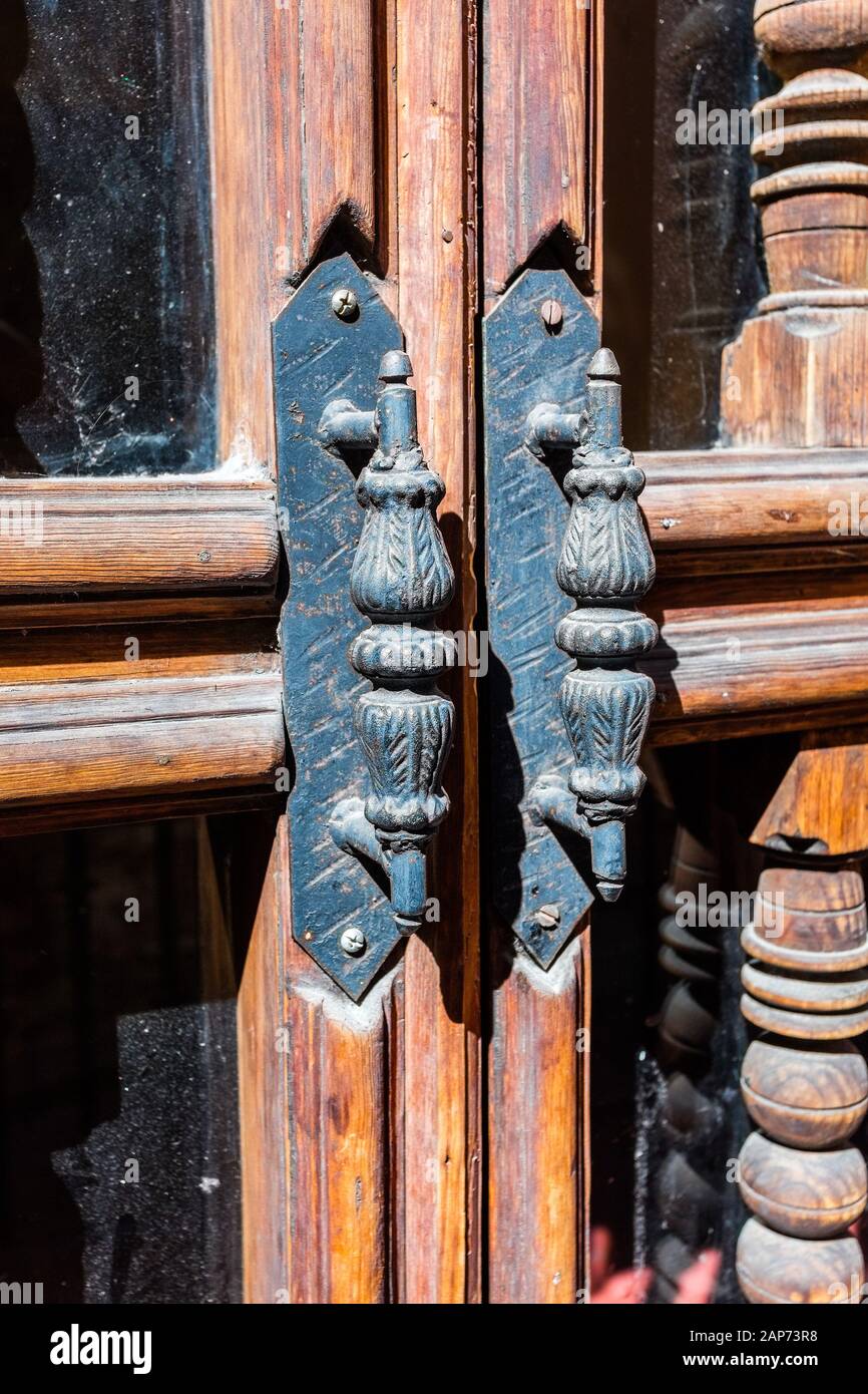 Old metal handle with the woodworm holes on the door Stock Photo