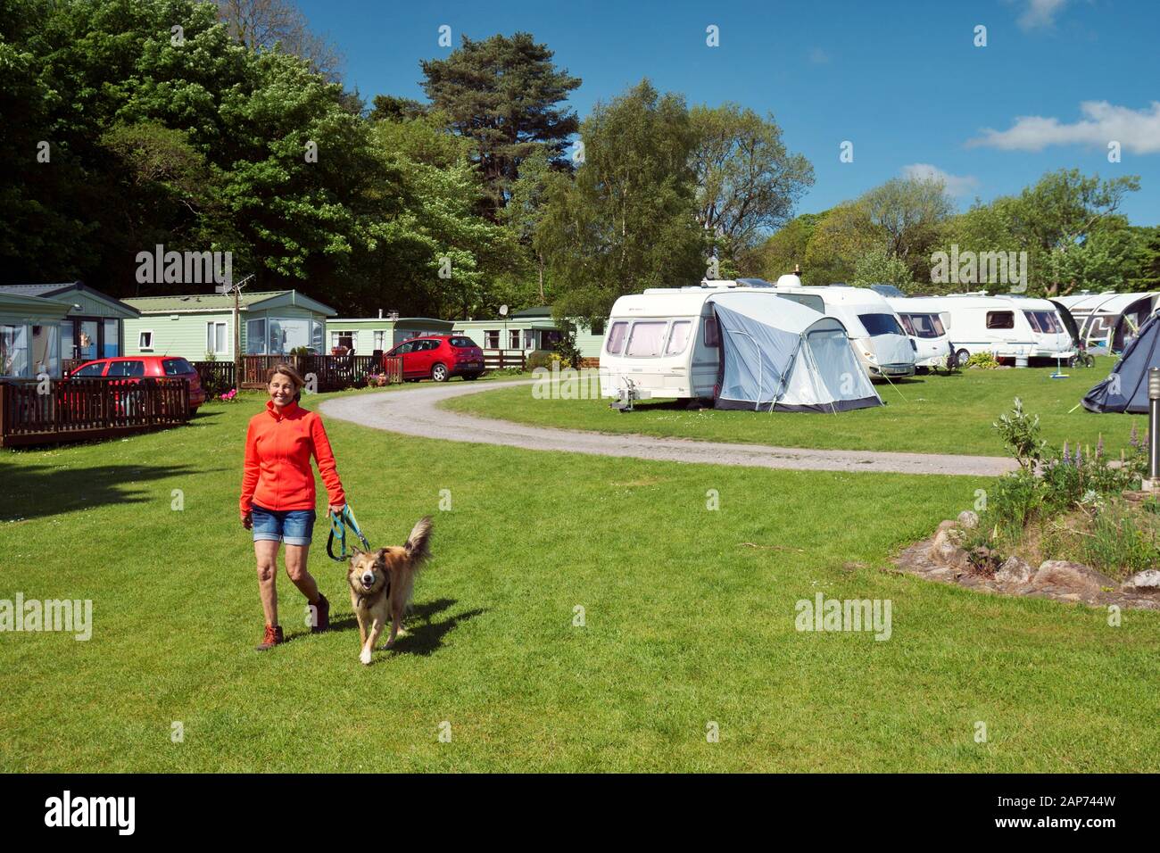 Caravan park and camping campsite at Sandyhills near Dalbeattie on the Solway Firth,southern Scotland. Young woman walking dog. Pet friendly holiday Stock Photo