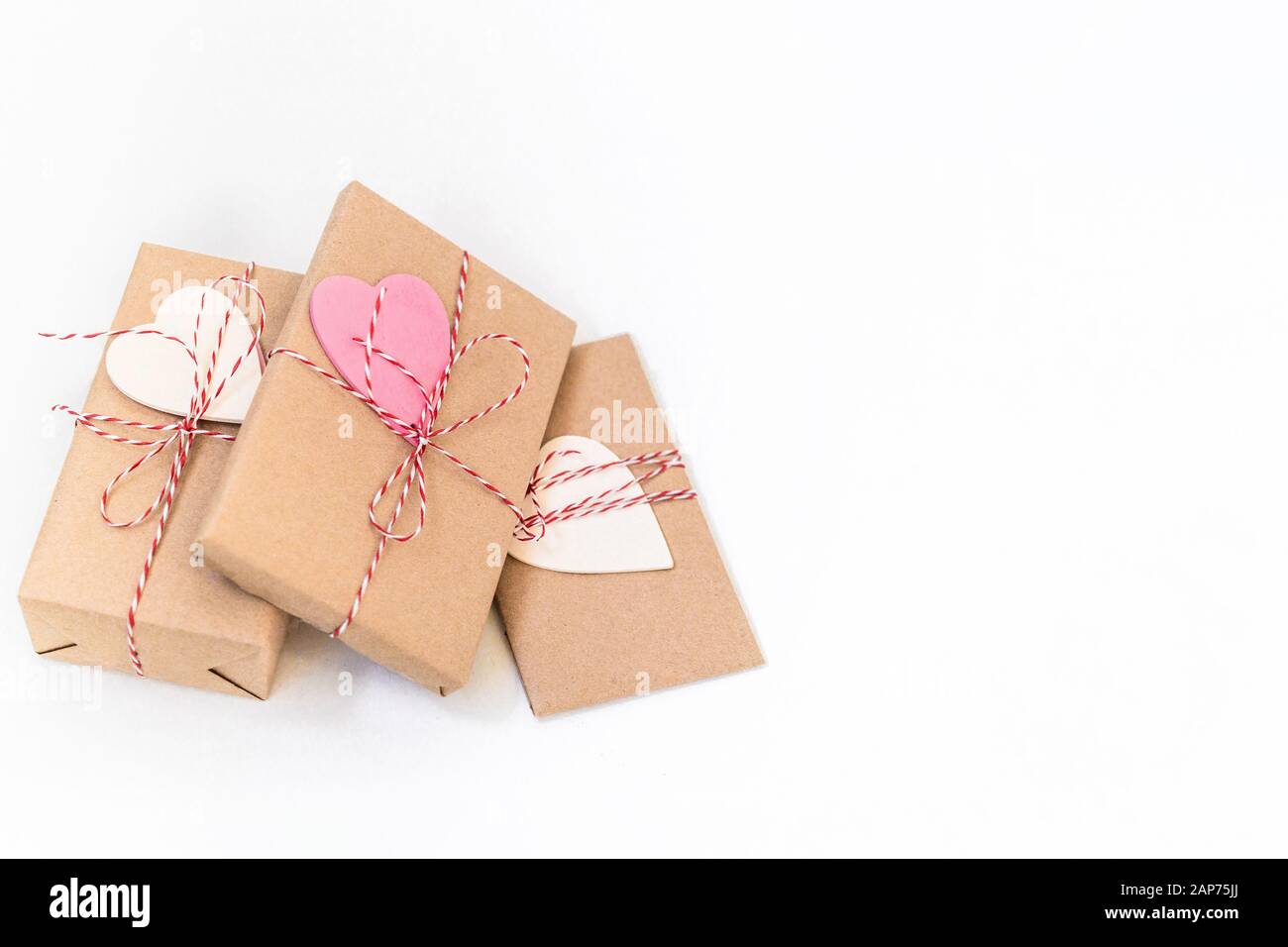 Gift boxes wrapped in craft paper and decorated with red ribbon and ...