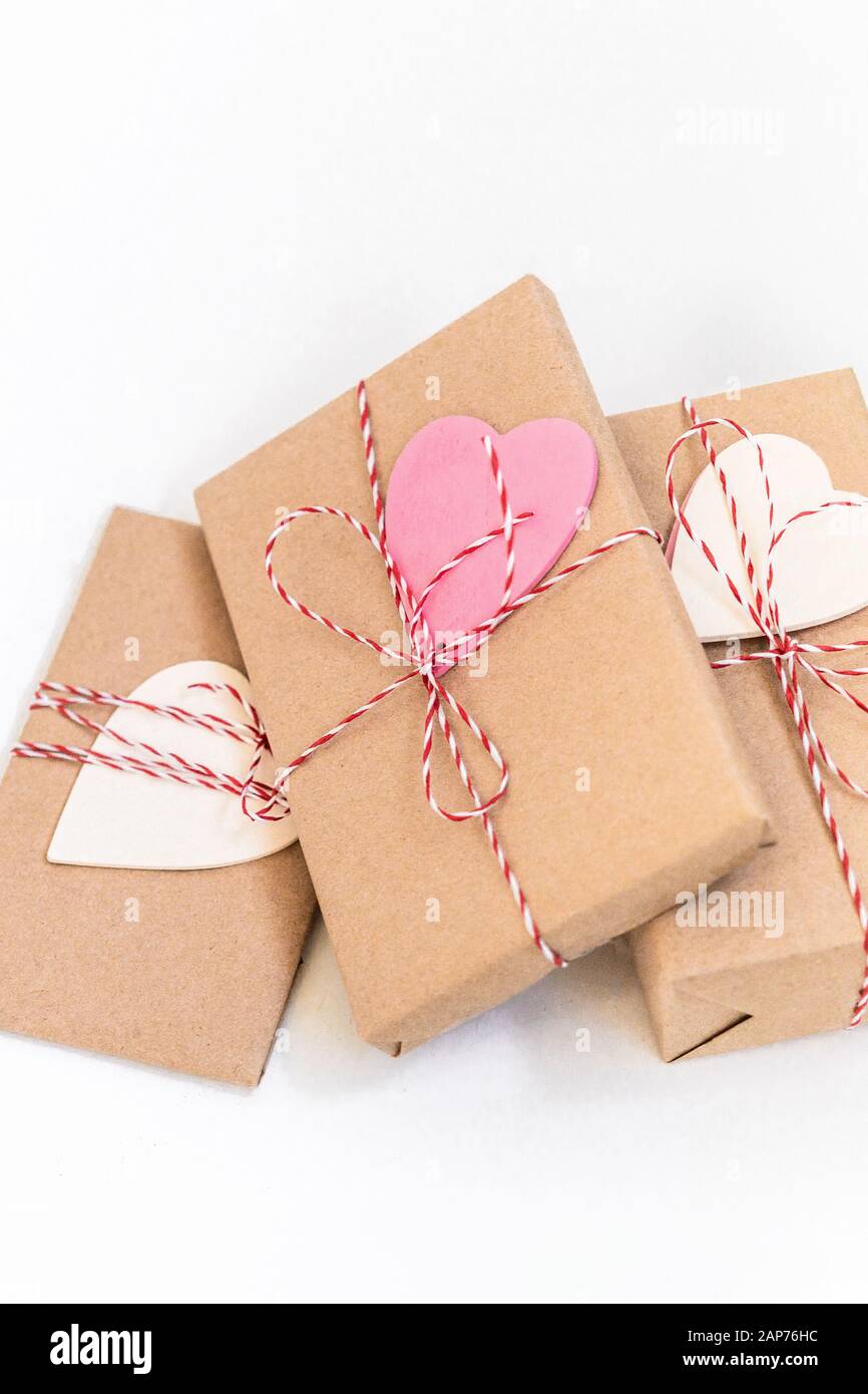 Gift boxes wrapped in craft paper and decorated with red ribbon and ...