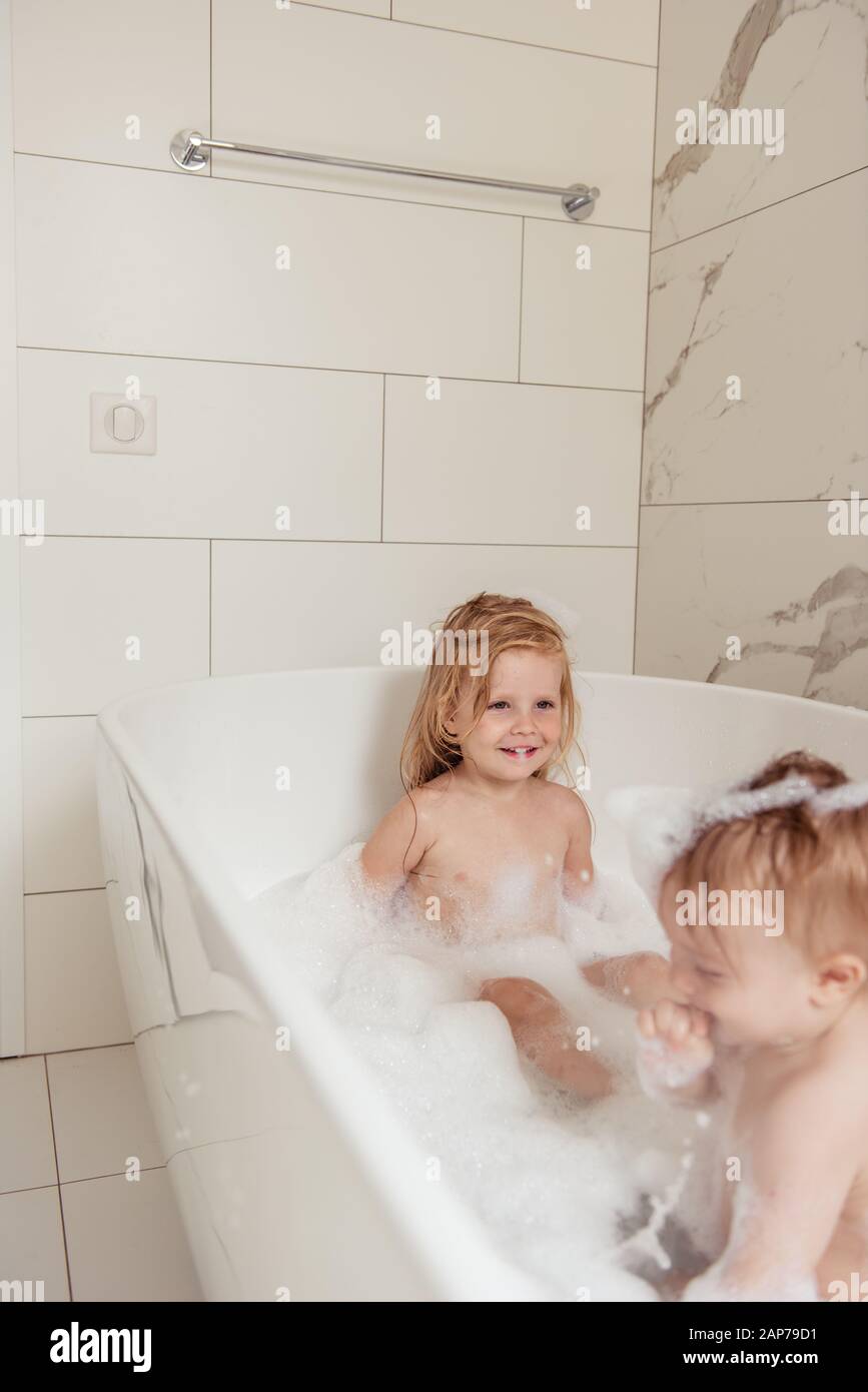 little brother and sister bathing in a foam bath Stock Photo
