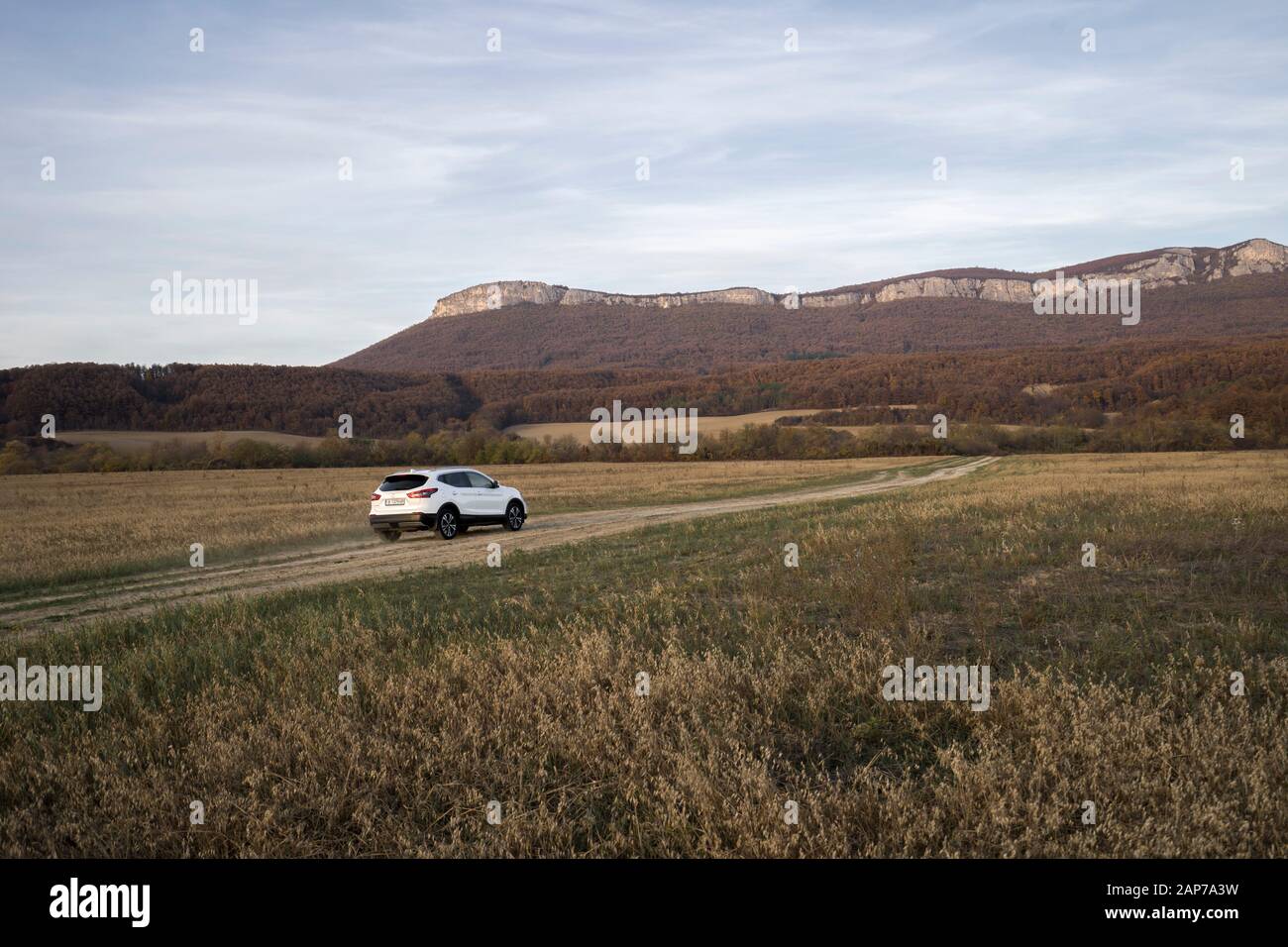 SUV car in a dusty field in Bulgaria low angle at sunset Stock Photo