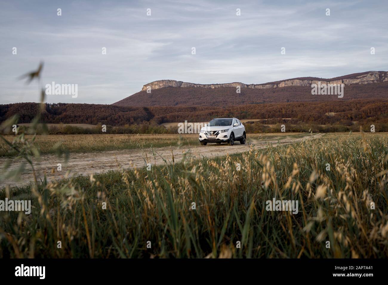 SUV car in a dusty field in Bulgaria low angle at sunset Stock Photo