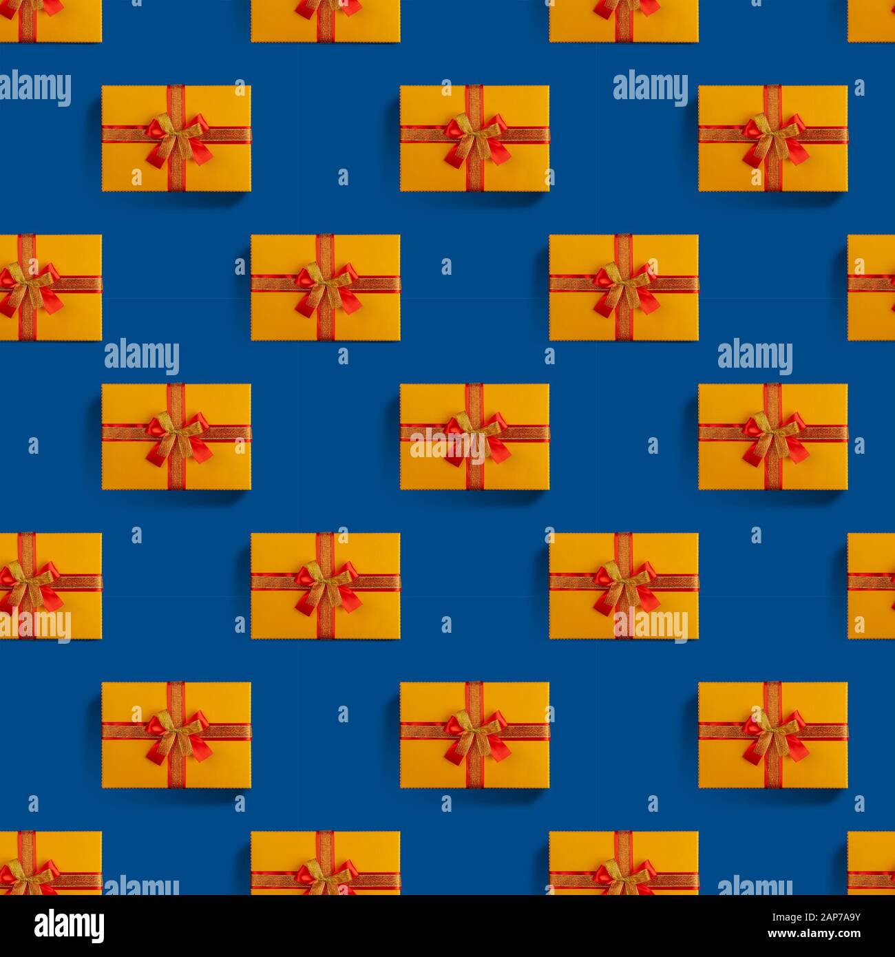 Seamless pattern of orange gift box with a gold and red ribbon on a ...