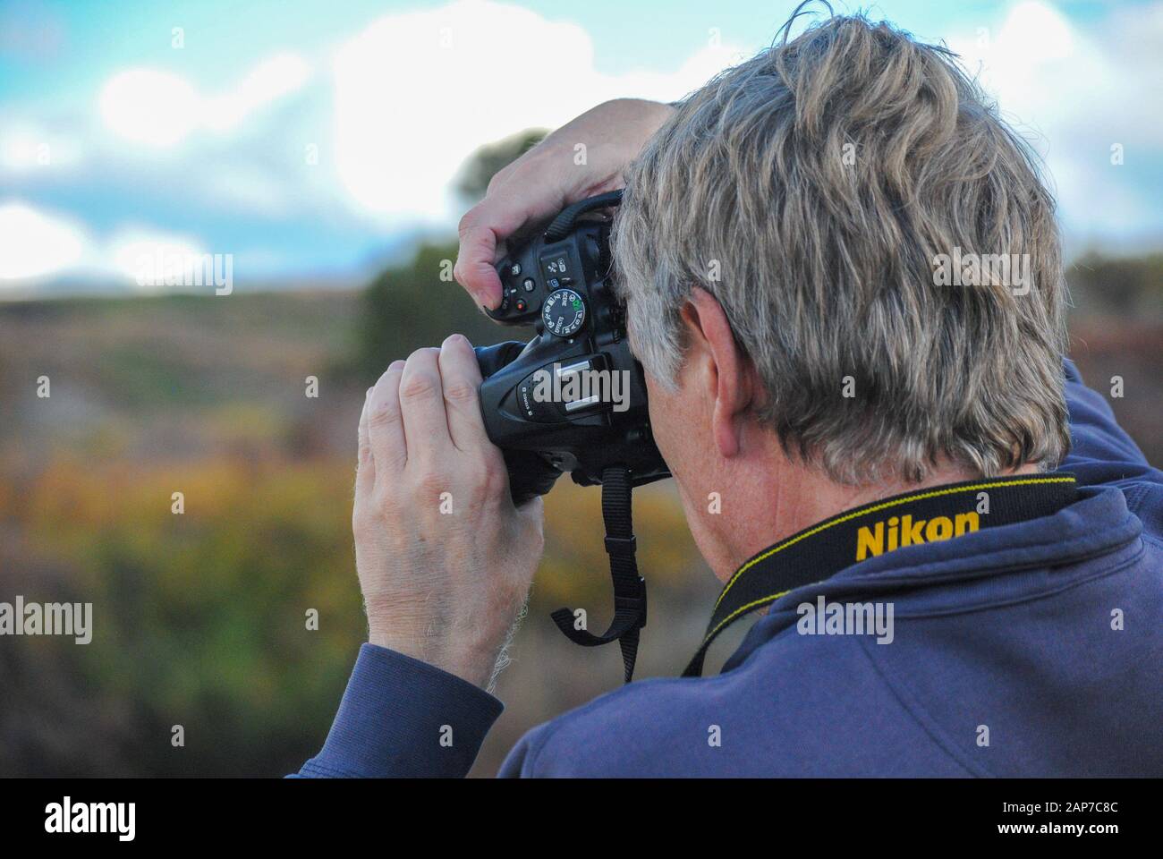 Photographer taking photo with Nikon camera Stock Photo
