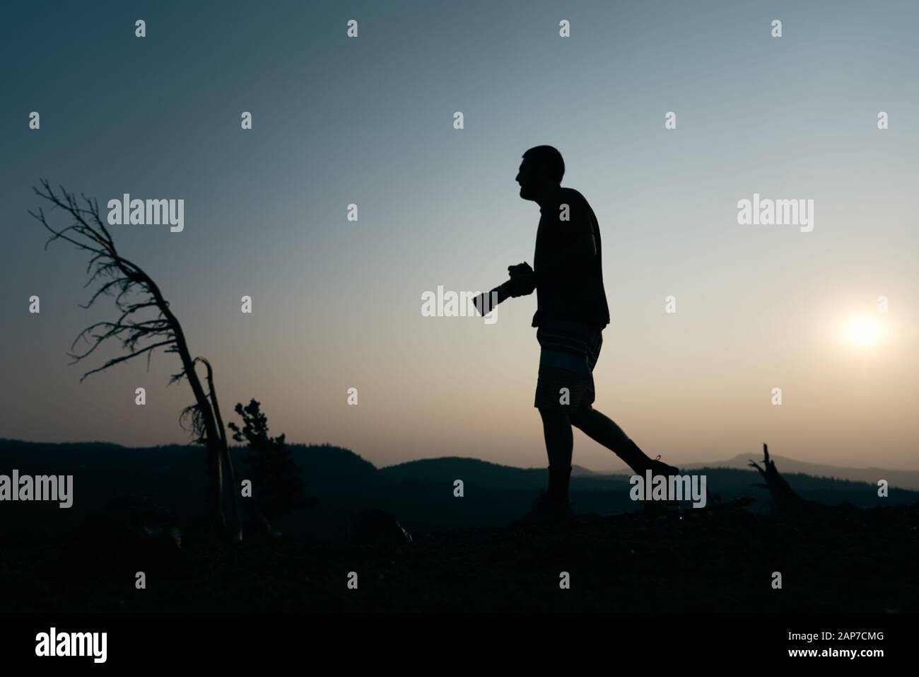 Silhouette of Man Holding Camera at Sunset Stock Photo - Alamy