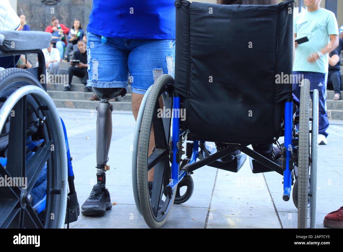 Disable people with prosthetic leg close to wheelchairs gather in public space Stock Photo