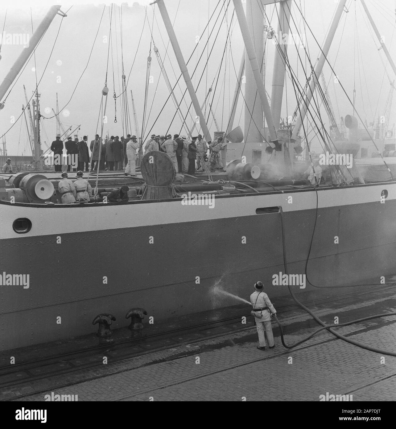 Fire aboard the Badagiy Palm in the Waalhaven in Rotterdam. Firefighters descend in the hold with oxygen masks Date: March 28, 1961 Location: Rotterdam, Zuid-Holland Keywords: fires, firefighters Personal name: Badagiy Palm Stock Photo