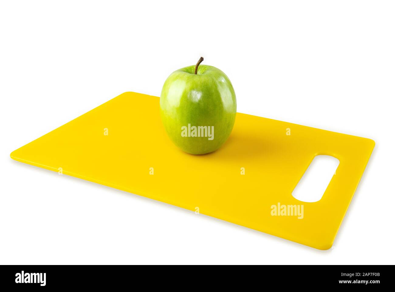Green Apple on Yellow Cutting Board White Background Stock Photo