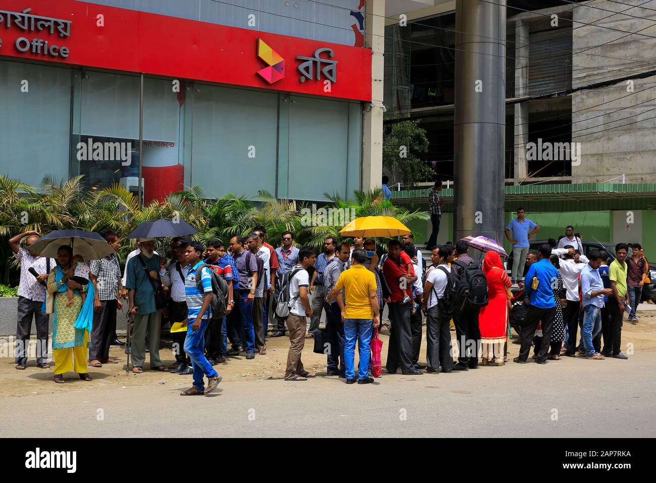 Commuters wait for city bus in Dhaka, Bangladesh. Stock Photo