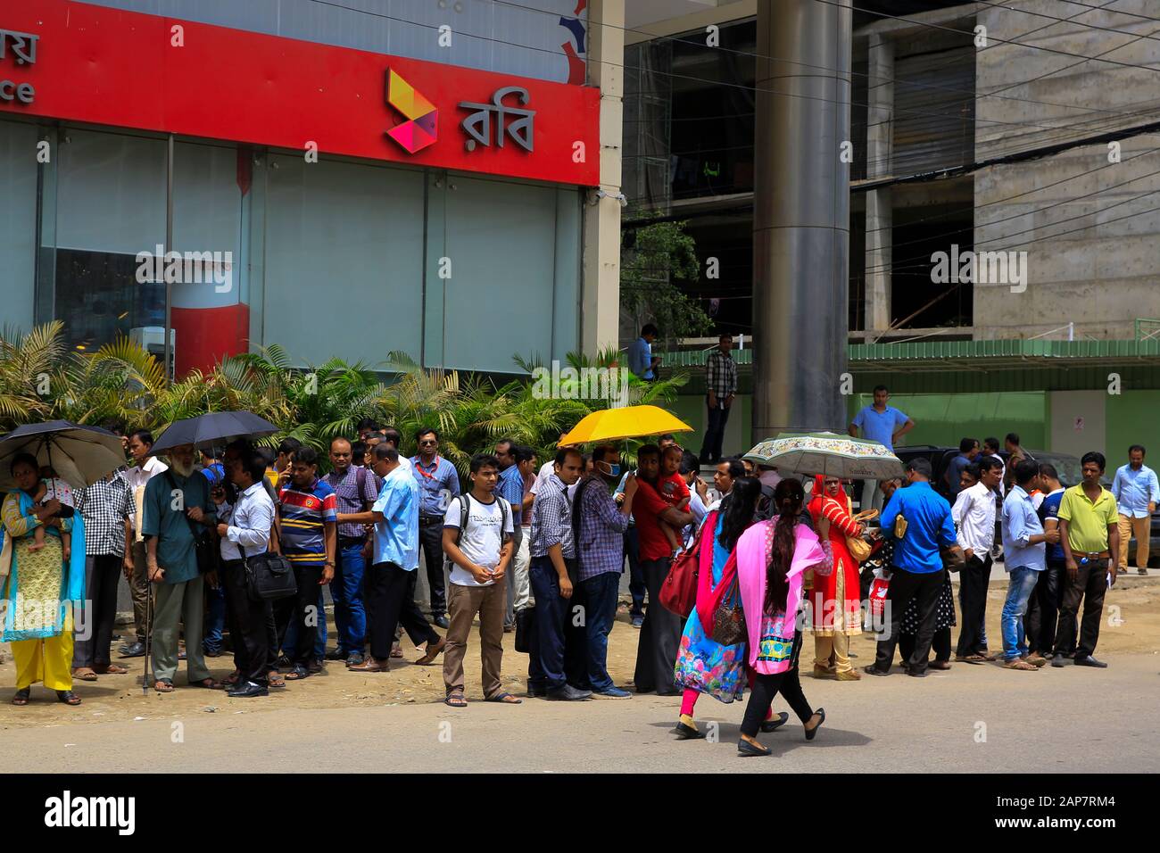Commuters wait for city bus in Dhaka, Bangladesh. Stock Photo
