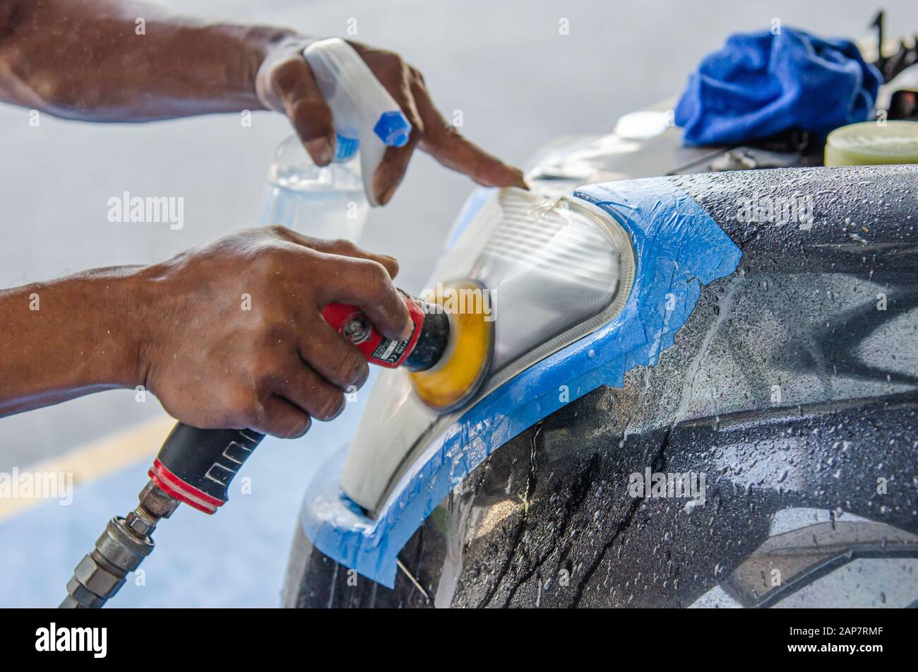 mechanic's hand is polishing the car's headlight Stock Photo Alamy