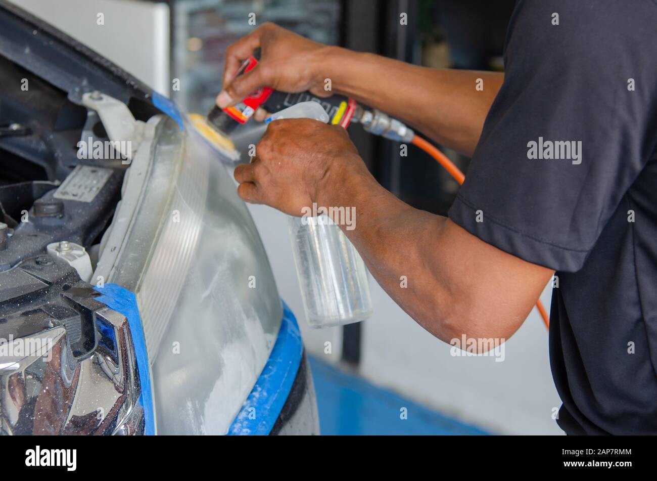 mechanic's hand is polishing the car's headlight Stock Photo Alamy