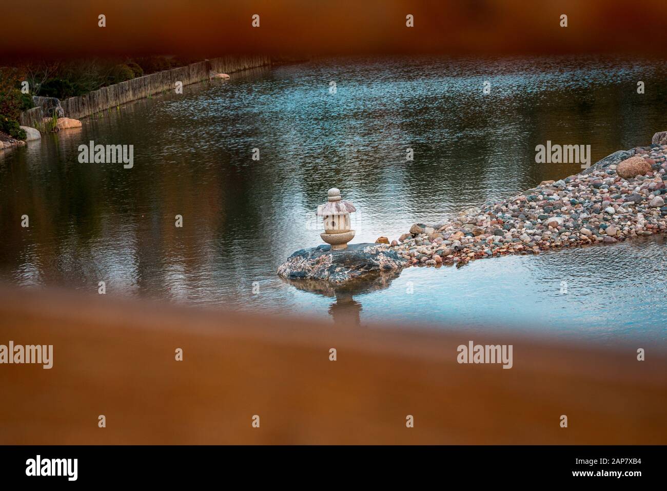 Isolated stone lantern on the lake at the Frederik Meijer Gardens Stock