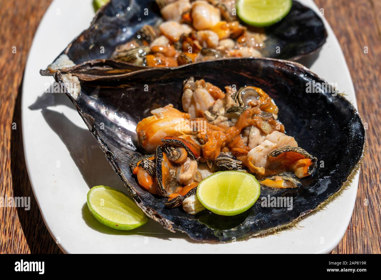 Raw clam meat in a large seashell served for food at a local restaurant