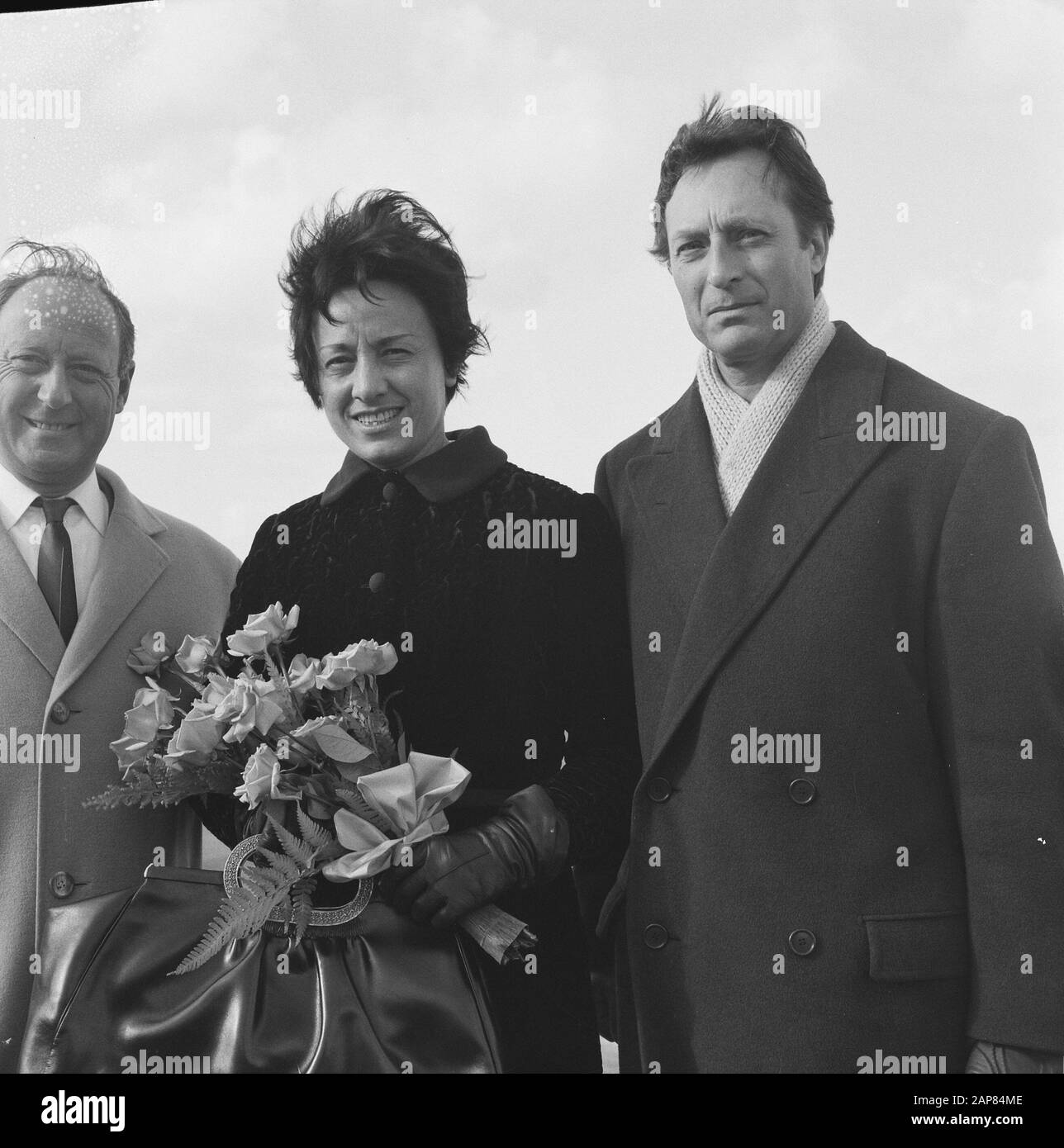 Arrival of Carlo Maria Giulini, guest conductor of the Philharmonia Orchestra in London, and his wife at Schiphol in connection with the Edison ceremony Description: arrival and departure, conductors, women, flowers, Giulini, Carlo Maria, Girolami, Marcella the Date: 29 October 1965 Location: Noord-Holland, Schiphol Keywords: arrival and departure, flowers, conductors, women Personal name: Girolami, Marcella de, Giulini, Carlo Maria Stock Photo