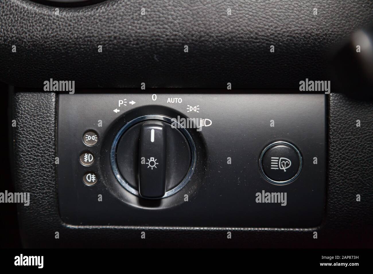 Closeup on the headlight switch control buttons and automatic adjust