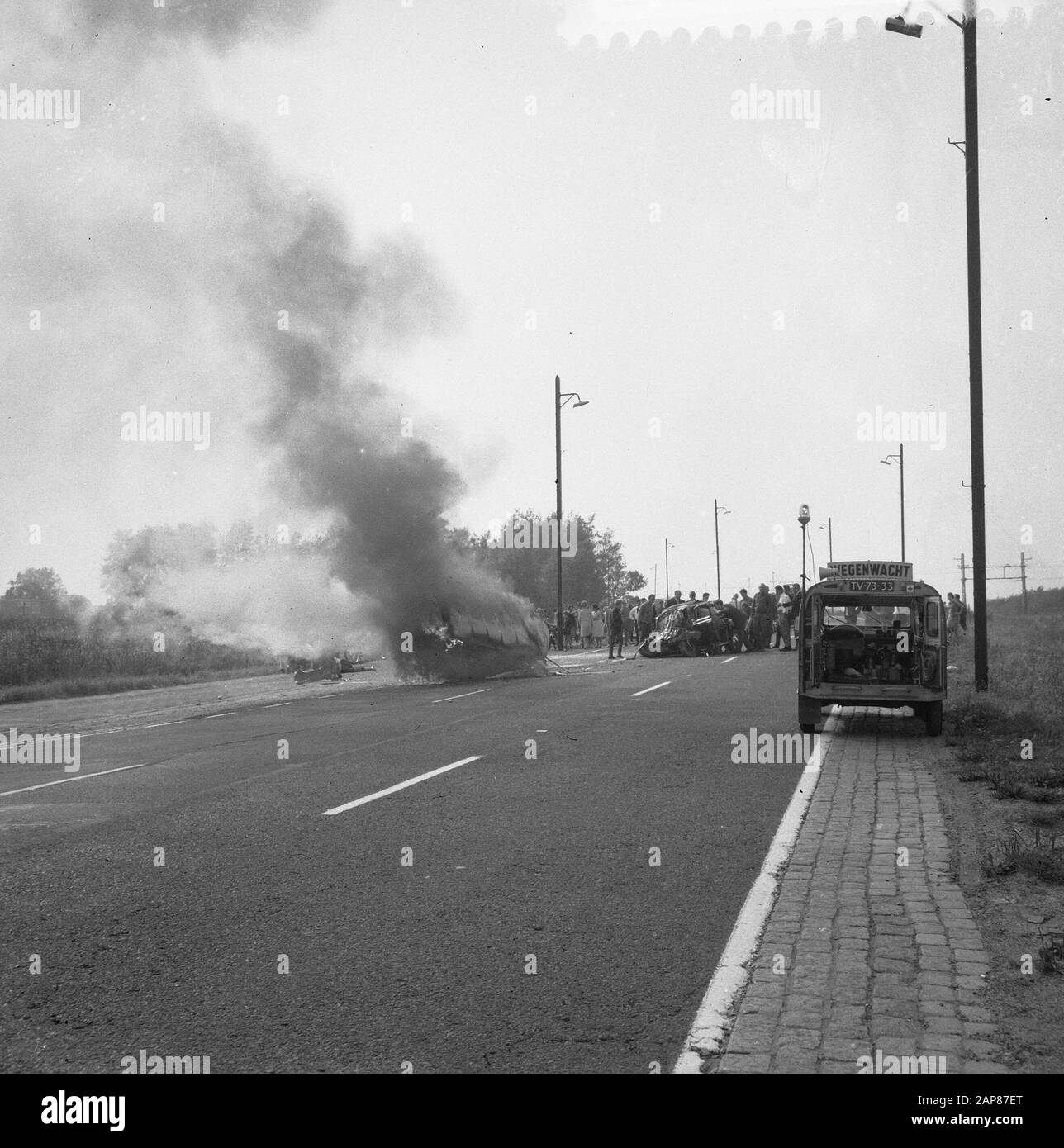 Car accident at the Haarlemmerweg in Amsterdam Description: Burning car with lots of smoke development Date: 10 september 1966 Location: Amsterdam, Noord-Holland Keywords: cars, car wrecks, fires Stock Photo