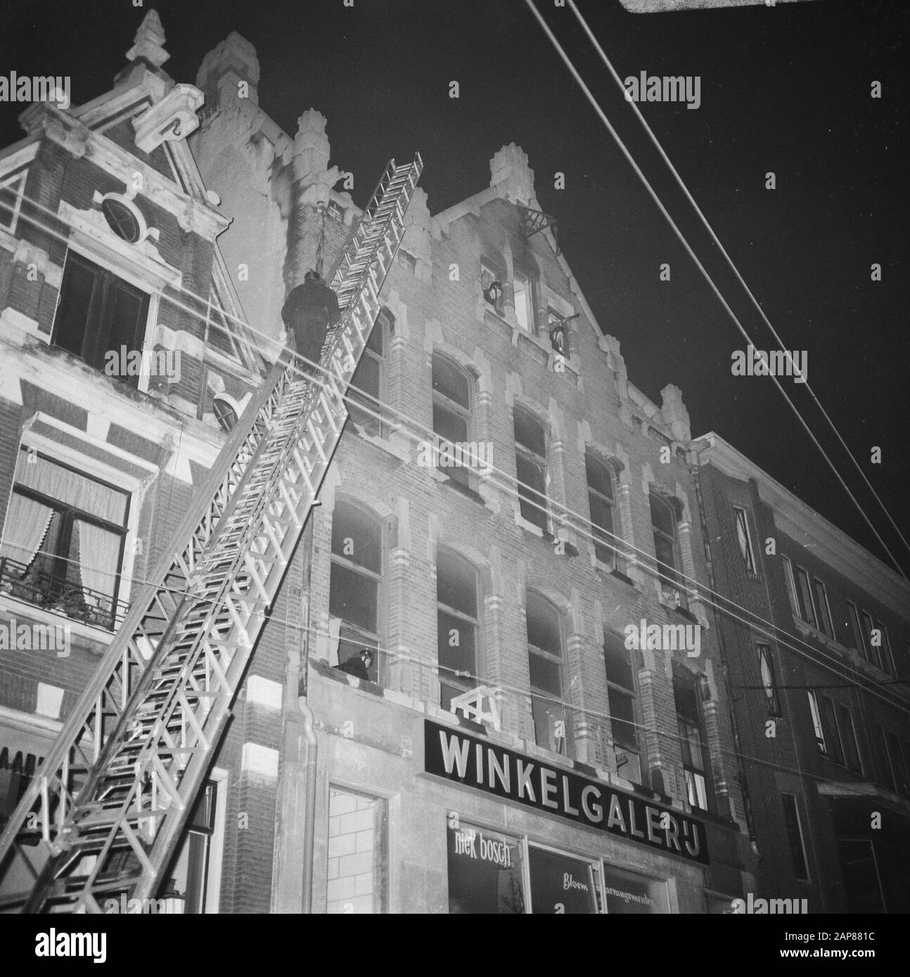Brand aan Amstel number 50 above shopping gallery. Fire brigade during extinguishing Date: January 2, 1968 Keywords: FIRE, extinguishing, fires, galleries, shops Personal name: Amstel Stock Photo