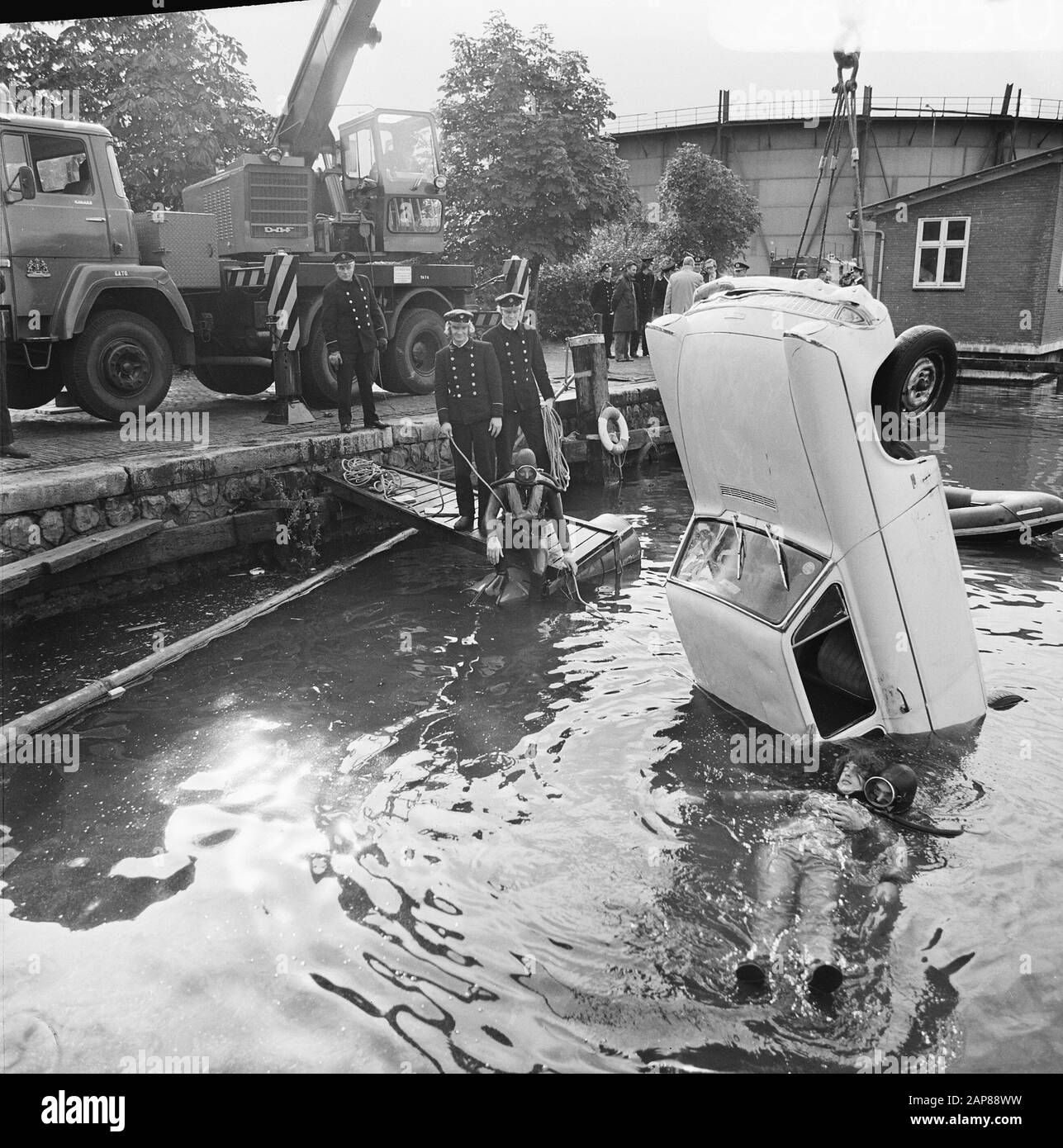 Amsterdam fire brigade presents diving team and demonstrates rescue drowning from car Date: October 11, 1973 Keywords: Cars, FIRE, demonstrations, rescues Stock Photo