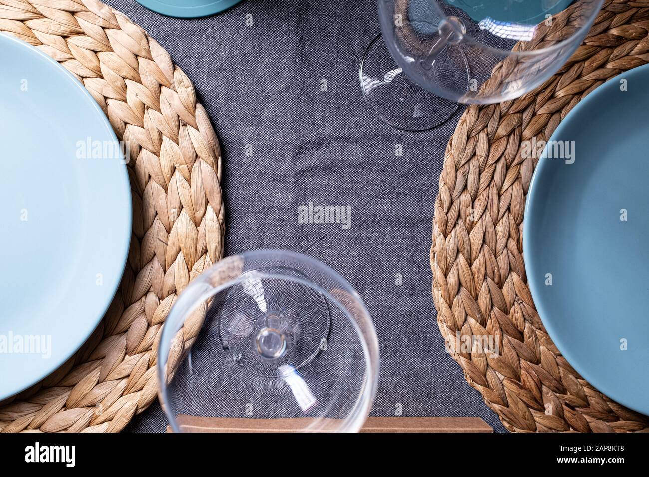 Crockery blue plates and wineglass on a grey fabrics prepared table Stock Photo