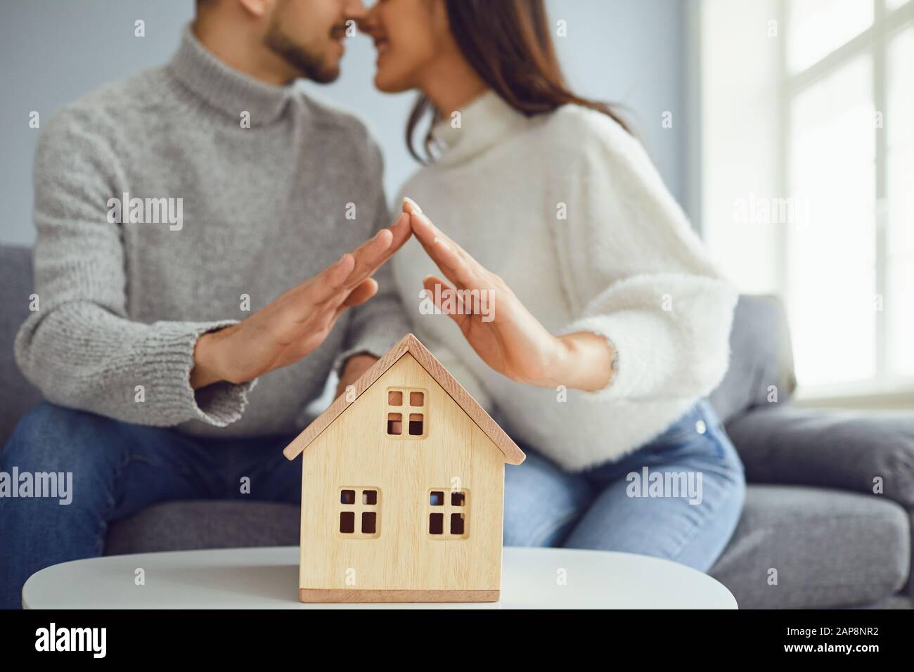 Hands of family couple holding a model of a house Stock Photo