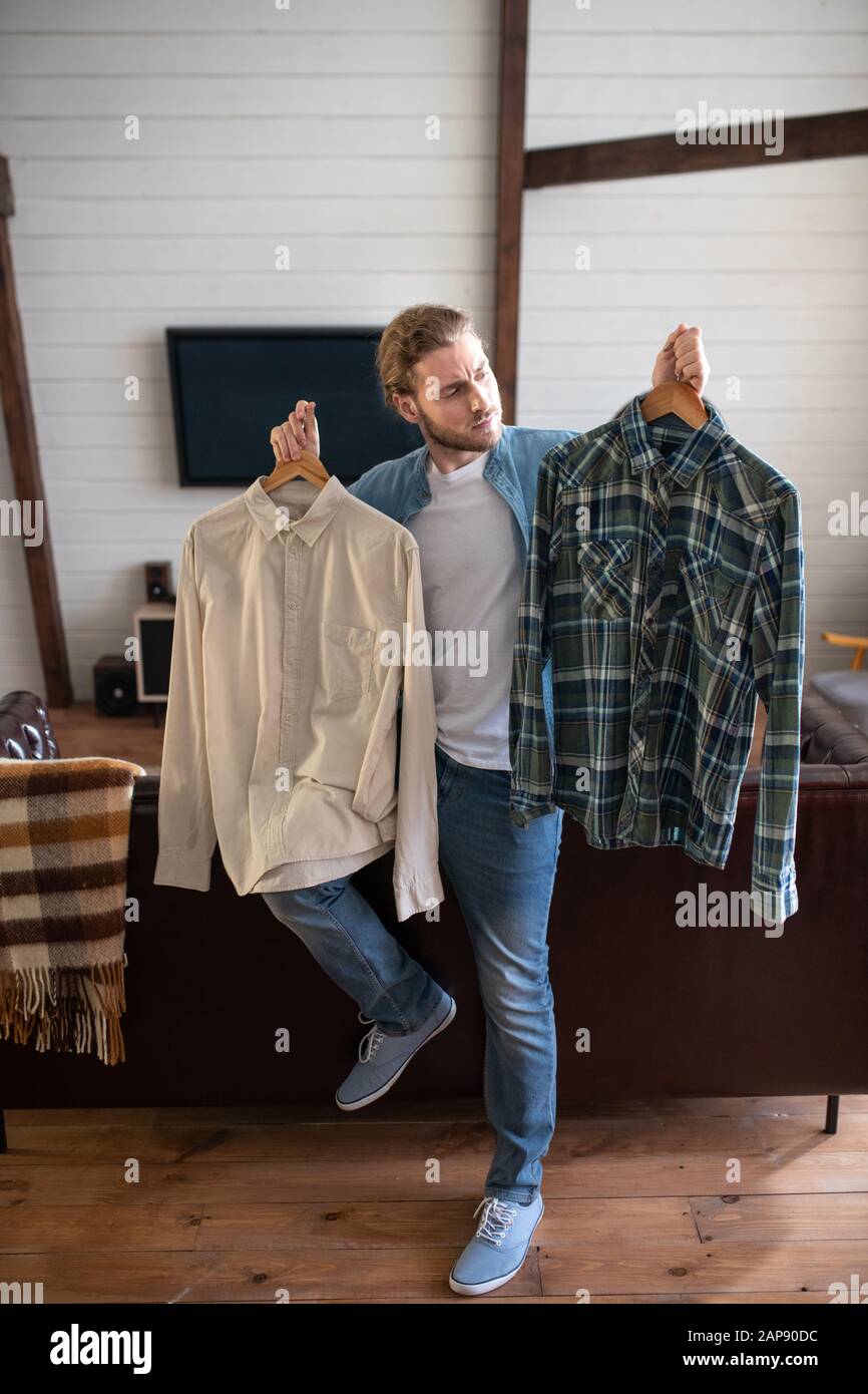 Man deciding on which shirt to wear Stock Photo