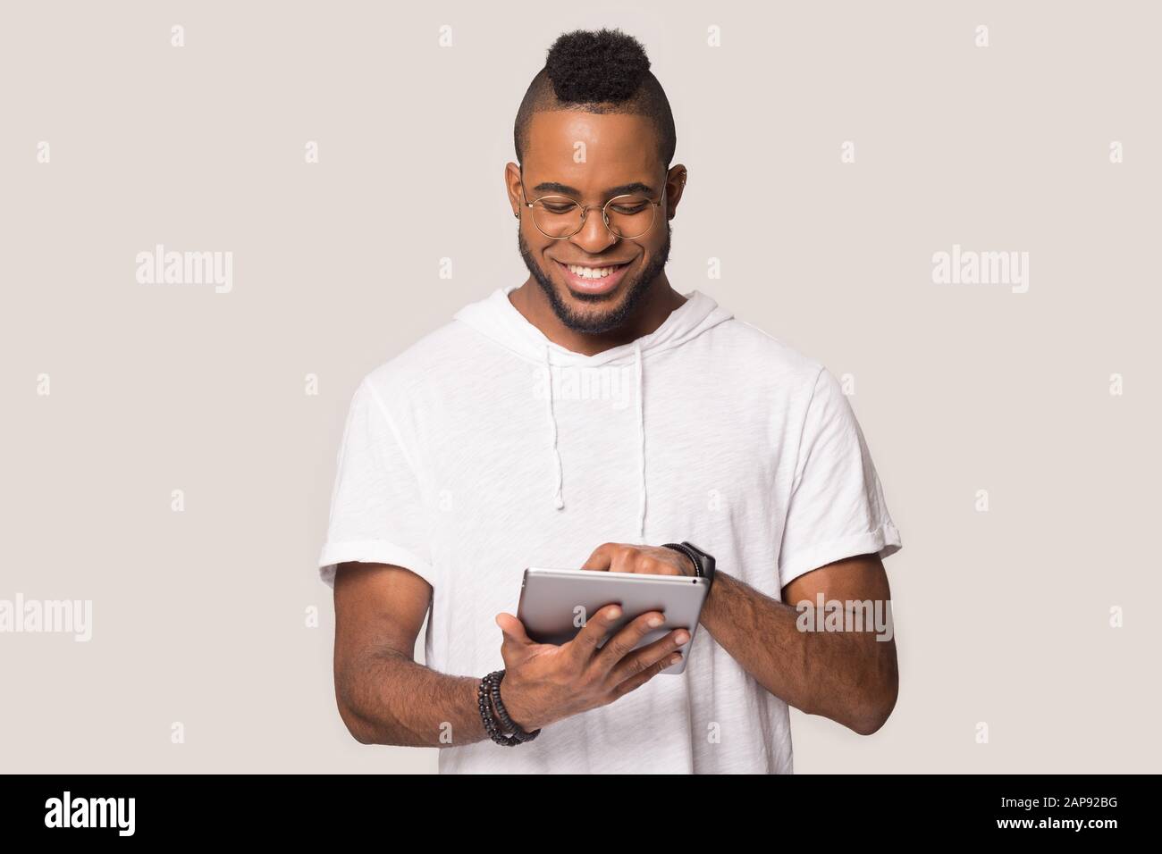 Happy black man using tablet shopping online in studio Stock Photo