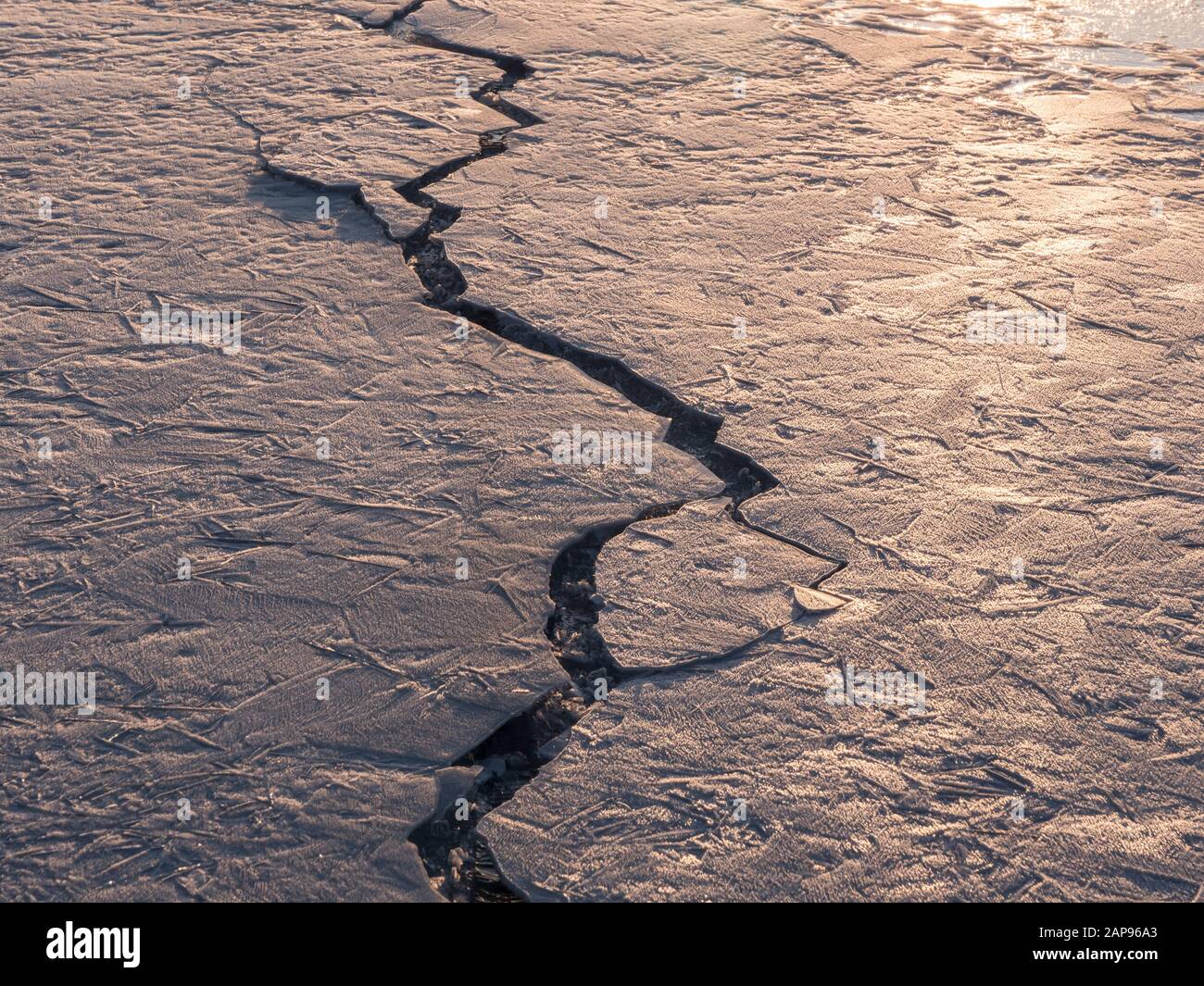 Cracked surface layer of ice at frozen lake Stock Photo - Alamy