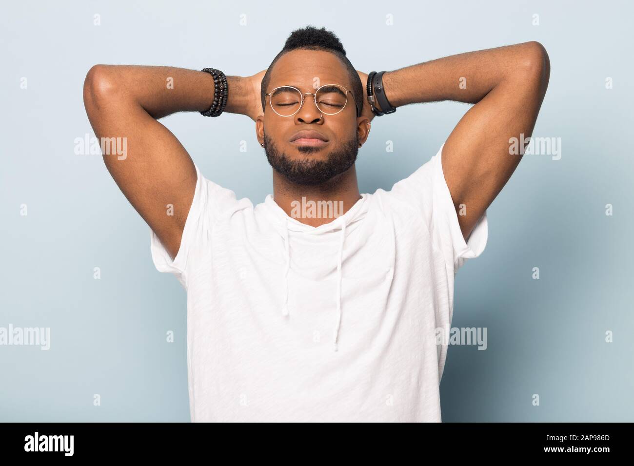 Calm black man relax with eyes closed hands over head Stock Photo