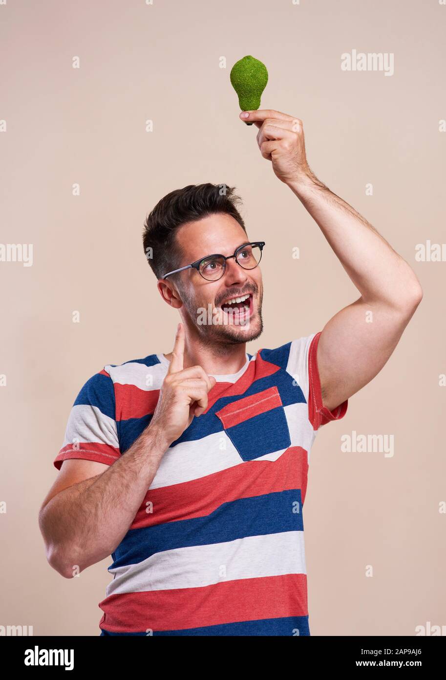 Happy man holding a energy efficient light bulb Stock Photo - Alamy