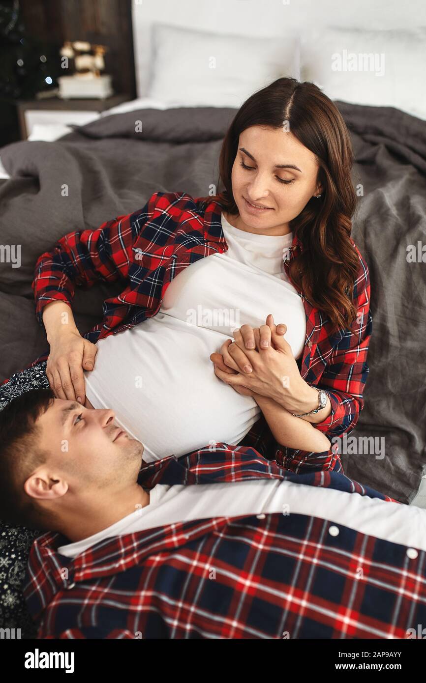 Beautiful pregnant couple in the bedroom. Preparing for childbirth