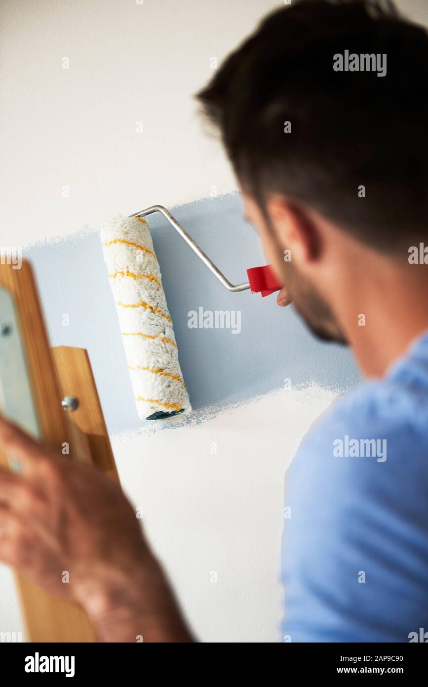 Rear view man painting wall hi-res stock photography and images - Alamy